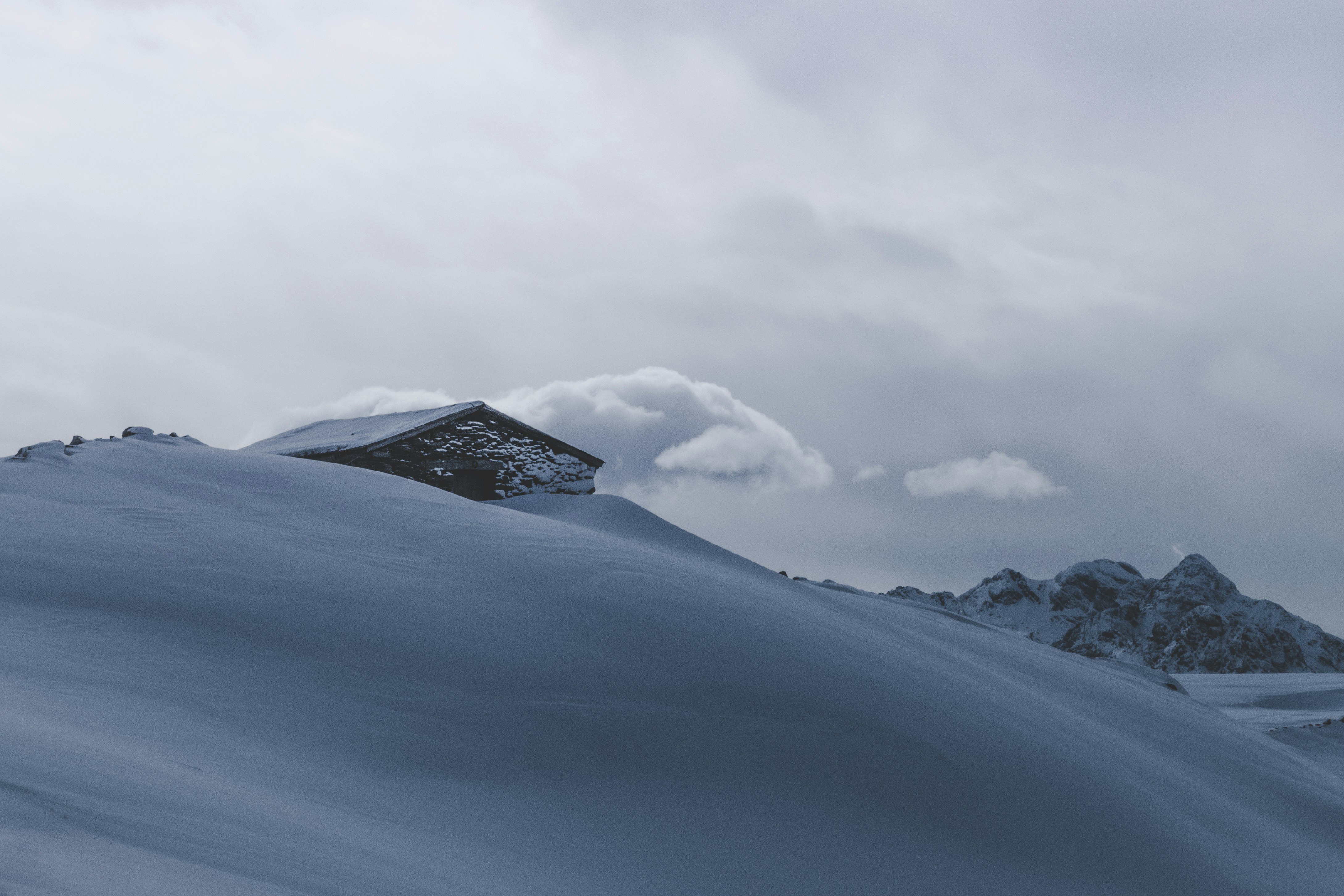 snow covered mountain under white skies